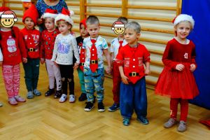 Dzieci stoją w półkolu i śpiewają piosenkę dla świętego Mikołaja