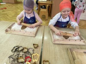 Dwie dziewczynki wałkują ciasto na pierniczki