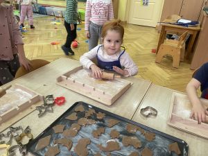 Dziewczynka wałkuje ciasto na pierniczki