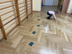 Dziewczynka czworakuje w sali gimnastycznej