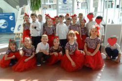 Zdjęcie grupowe dzieci, z grupy czwartej. Dzieci ubrane są w eleganckie stroje do tańca
