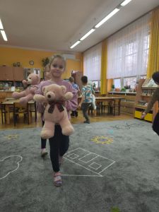Dziewczynka idzie po dywanie ze swoim misiem