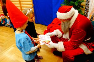 Dzieci z grupy 4 wręczają prezent mikołajowi z okazji jego imienin- książeczka z rysunkami dzieci i życzeniami