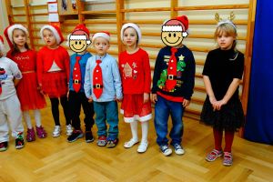 Dzieci stoją w półkolu i śpiewają Mikołajowi piosenkę