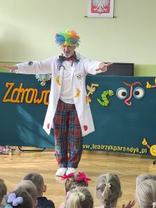 Aktor grający Pana Zdrówko w kolorowej peruce na głowie