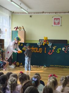 Dziewczynka wybiera zdrowe produkty, które pokazuje jej Pan zdrówko