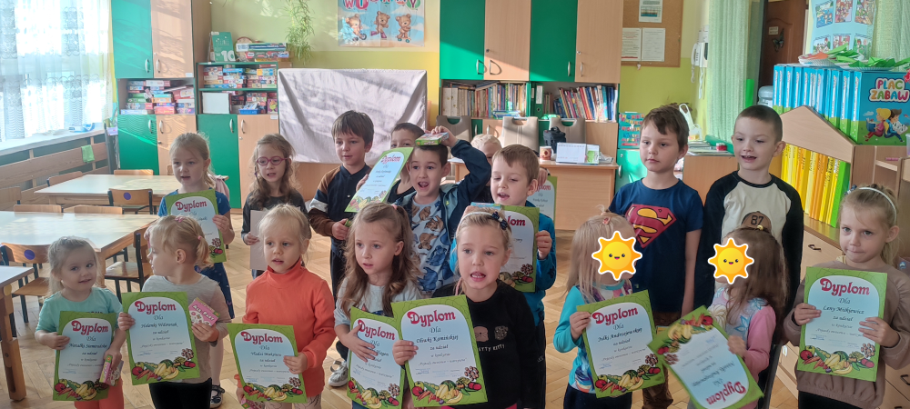 Grupa dzieci trzymająca dyplomy i nagrody za udział w konkursie.
