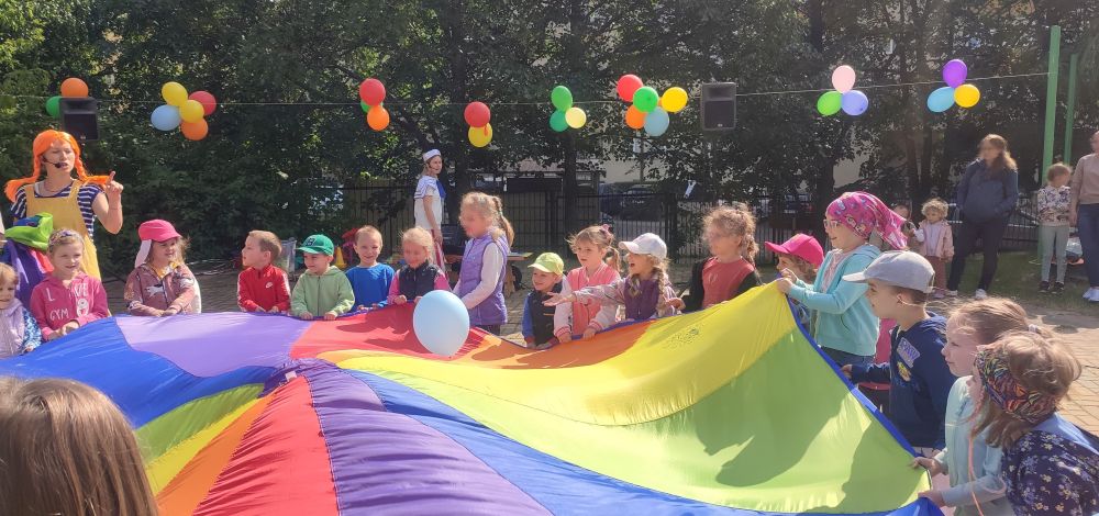 Dzieci bawią się chustą animacyjną na placu zabaw