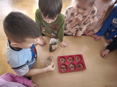 Chłopiec wrzuca ziarenka do foremki