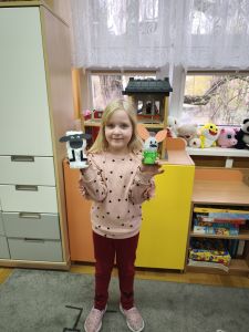 dziewczynka pokazuje zrobione prace- baranka i zajączka