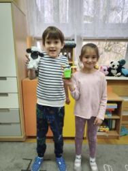 Chłopiec i dziewczynka pokazują zrobione prace- baranka i zajączka