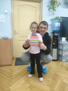 Tata i Dziewczynka trzymają w rękach zrobione przez siebie jajko z papieru