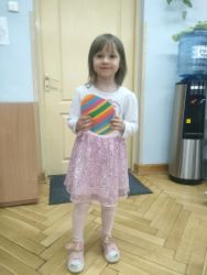 Dziewczynka trzyma w rękach zrobione przez siebie jajko z papieru